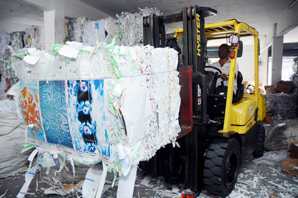 Forklift stack the shredded compacted paper before being sent to  paper mills for recycling